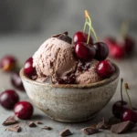 Bowl of dairy-free cherry chocolate ice cream with cherries and chocolate chunks